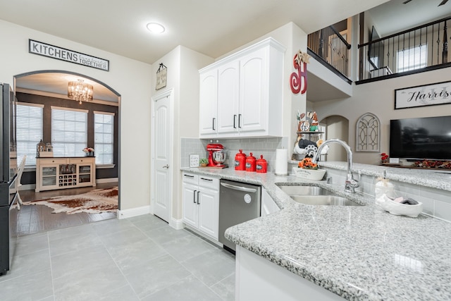 kitchen with light stone counters, white cabinets, sink, stainless steel appliances, and light hardwood / wood-style floors