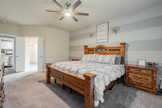 bedroom featuring ceiling fan, light colored carpet, and ensuite bathroom