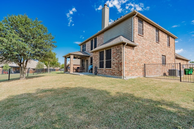 rear view of house featuring a lawn and a patio area