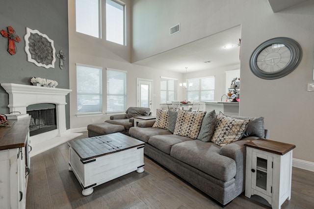 living room featuring a high ceiling, dark hardwood / wood-style floors, and a chandelier