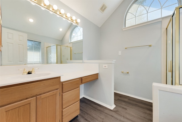 bathroom featuring walk in shower, wood-type flooring, lofted ceiling, and vanity