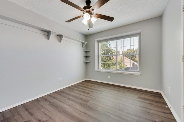 empty room with ceiling fan, a textured ceiling, and wood-type flooring