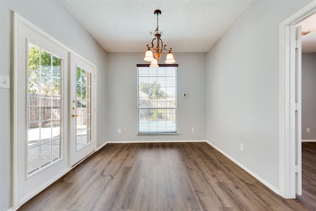 interior space featuring an inviting chandelier, hardwood / wood-style floors, and a textured ceiling