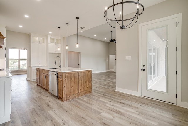 kitchen featuring white cabinetry, light hardwood / wood-style flooring, stainless steel dishwasher, a kitchen island with sink, and sink