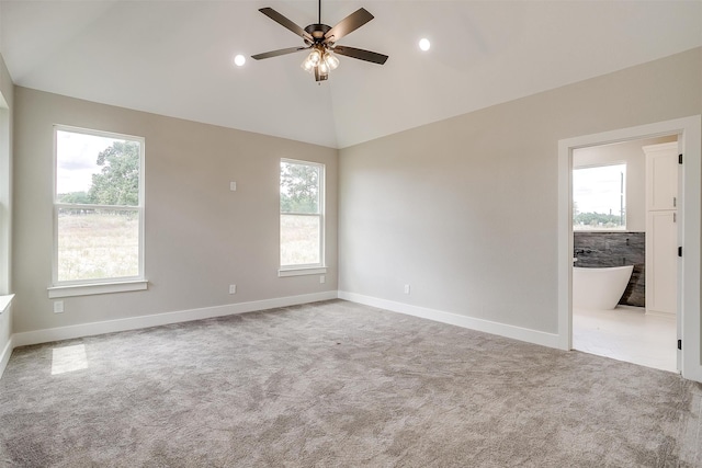 spare room featuring ceiling fan, light colored carpet, and plenty of natural light