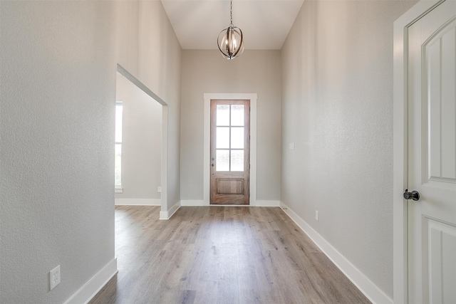 entryway featuring light hardwood / wood-style floors and a chandelier