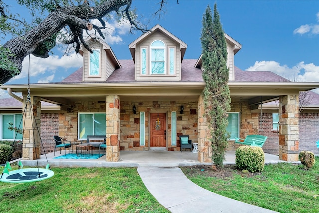 13823 Llano Dr, Weatherford, TX 76087 - view of front of home with stone siding, covered porch, a front yard, and a shingled roof