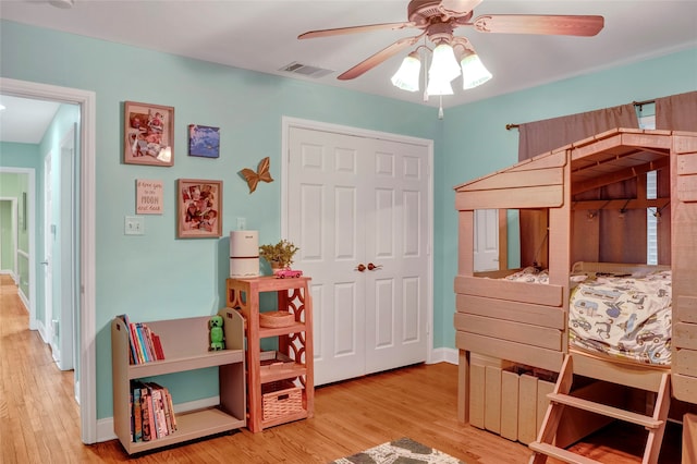 bedroom featuring light wood-type flooring, ceiling fan, and a closet