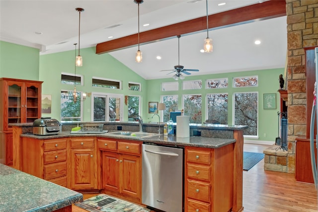 kitchen featuring ceiling fan with notable chandelier, a stone fireplace, dishwasher, beamed ceiling, and light wood-type flooring