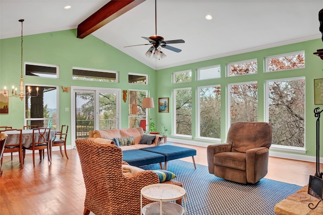 living room featuring beam ceiling, ceiling fan with notable chandelier, plenty of natural light, and light hardwood / wood-style floors