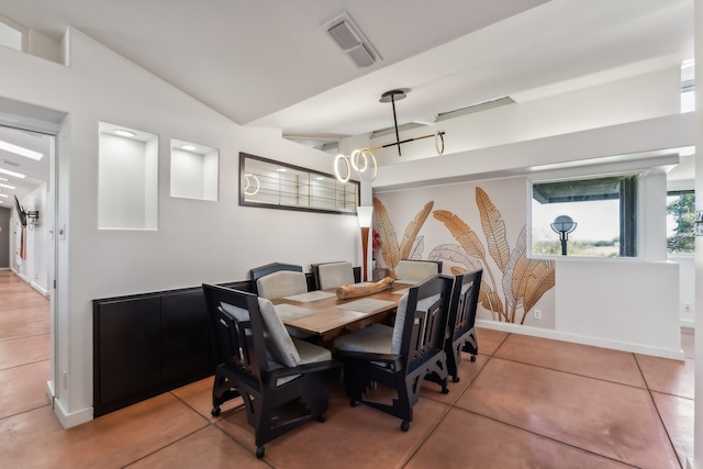 dining area featuring tile patterned flooring, vaulted ceiling, baseboards, and visible vents