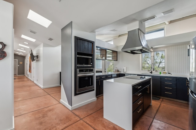 kitchen featuring oven, black electric cooktop, a kitchen island, island range hood, and built in microwave