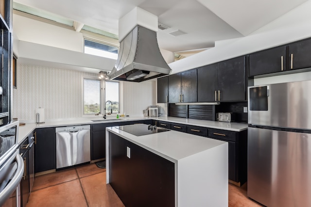 kitchen featuring dark cabinetry, island range hood, appliances with stainless steel finishes, and a sink