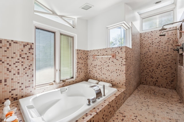 bathroom featuring a bath and tile walls