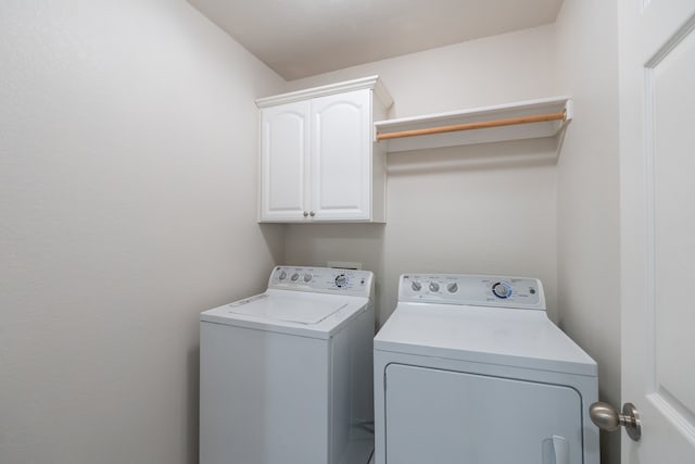 washroom featuring cabinets and separate washer and dryer