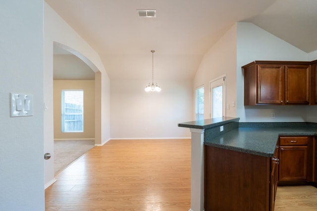 6532 Sierra Madre Dr, Fort Worth, TX 76179 - kitchen featuring lofted ceiling, light wood finished floors, visible vents, arched walkways, and dark countertops