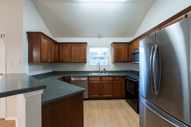 kitchen featuring light wood-type flooring, sink, vaulted ceiling, kitchen peninsula, and stainless steel appliances