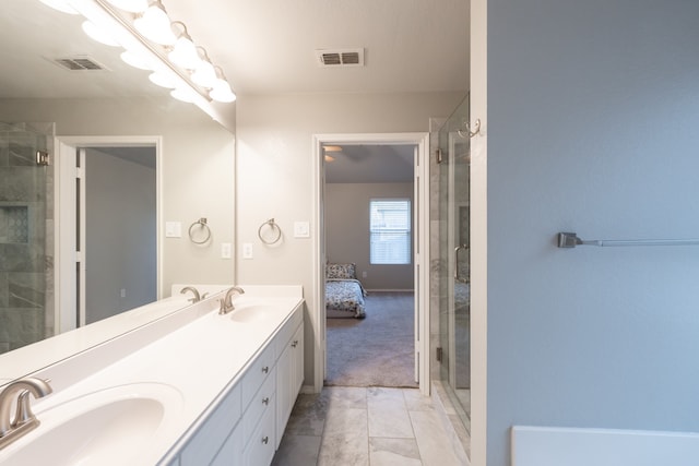 bathroom featuring a shower with shower door and vanity