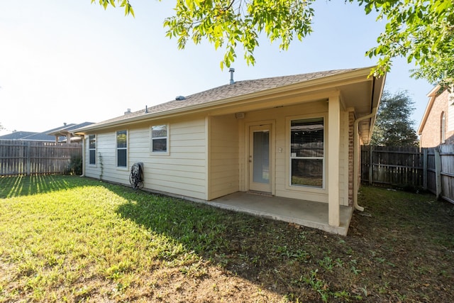 back of house featuring a patio and a yard