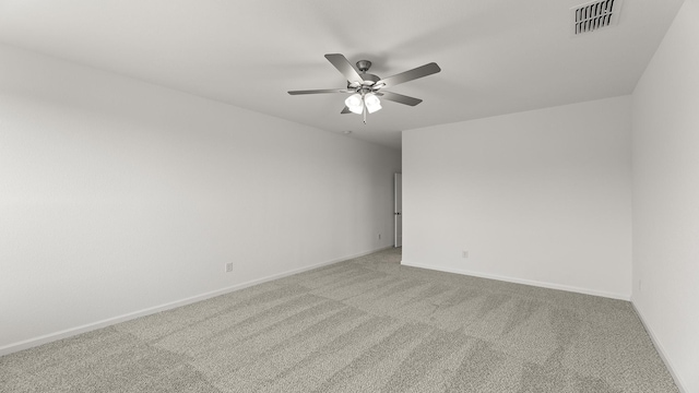 spare room featuring a ceiling fan, light colored carpet, visible vents, and baseboards