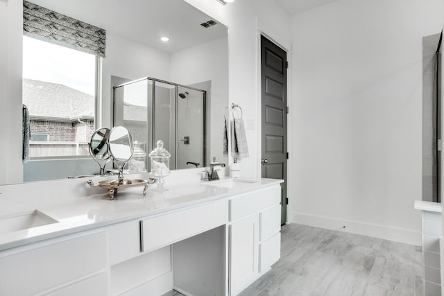 bathroom featuring an enclosed shower, vanity, and hardwood / wood-style flooring