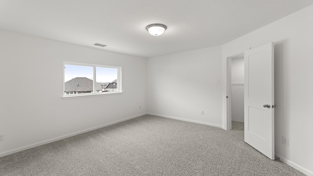 unfurnished room featuring baseboards, visible vents, and carpet flooring