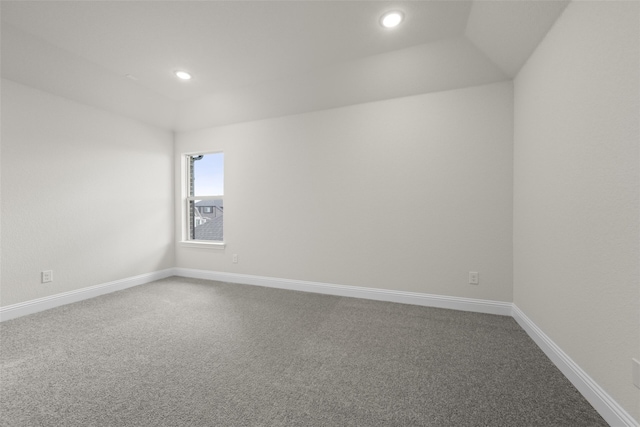 empty room featuring lofted ceiling and carpet