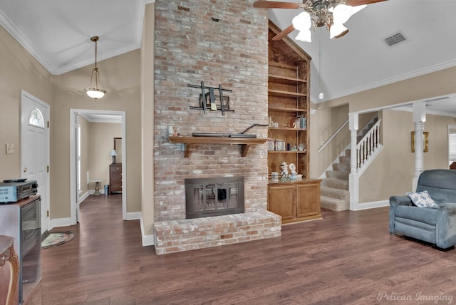 living room with ornamental molding, a brick fireplace, ceiling fan, and dark hardwood / wood-style flooring