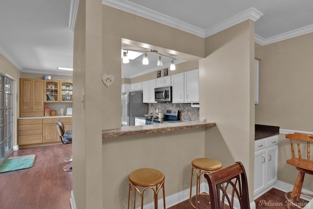 kitchen with appliances with stainless steel finishes, crown molding, decorative backsplash, and dark hardwood / wood-style floors