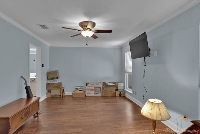 sitting room featuring wood-type flooring, ornamental molding, and ceiling fan