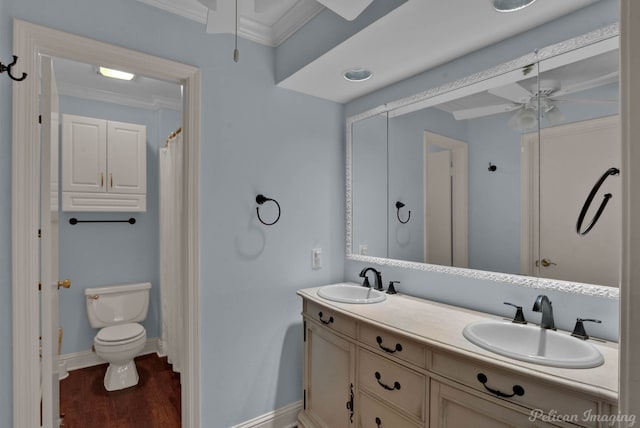 bathroom featuring ceiling fan, vanity, toilet, crown molding, and hardwood / wood-style floors