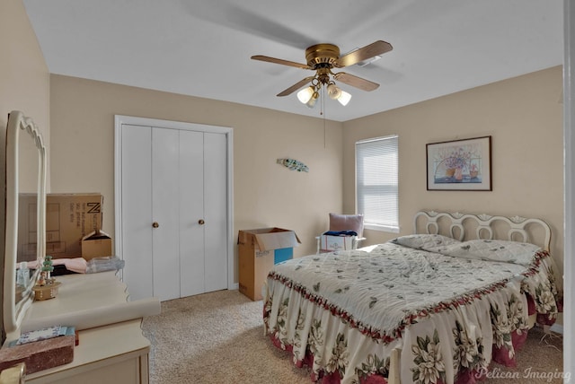 carpeted bedroom featuring ceiling fan and a closet