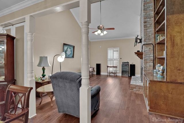 living room with ceiling fan, ornamental molding, hardwood / wood-style floors, a fireplace, and vaulted ceiling