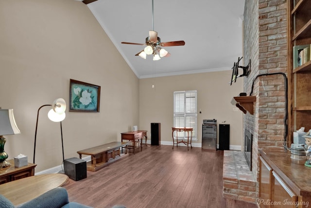 living room with high vaulted ceiling, a brick fireplace, hardwood / wood-style floors, crown molding, and ceiling fan