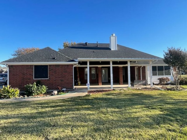 rear view of property with a lawn