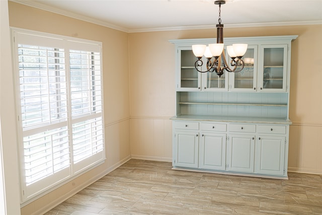 unfurnished dining area with a notable chandelier, light hardwood / wood-style floors, and ornamental molding