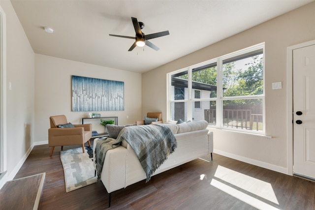 living room with ceiling fan and dark wood-type flooring