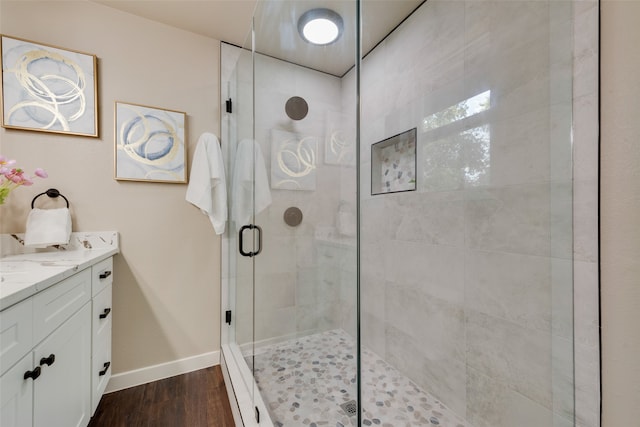 bathroom featuring wood-type flooring, vanity, and a shower with shower door