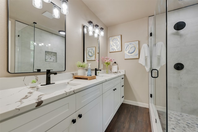 bathroom with wood-type flooring, vanity, and a shower with shower door