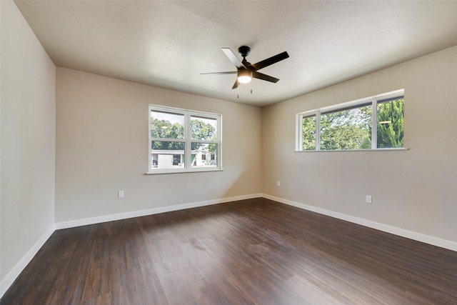 empty room featuring dark wood-type flooring, ceiling fan, a healthy amount of sunlight, and a textured ceiling