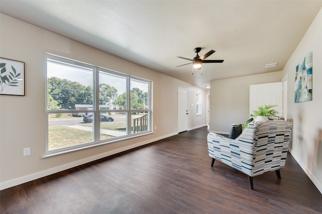 sitting room with a wealth of natural light, ceiling fan, dark hardwood / wood-style floors, and a textured ceiling