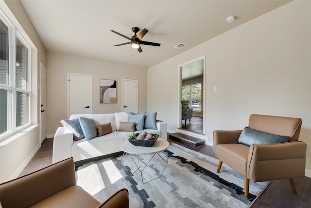 living room with dark hardwood / wood-style flooring and ceiling fan