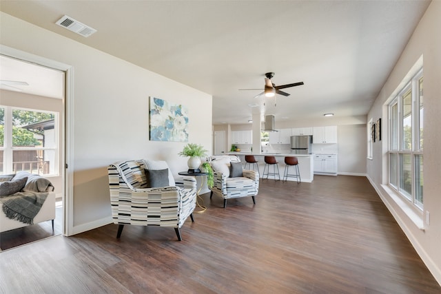 living room featuring ceiling fan and dark hardwood / wood-style flooring