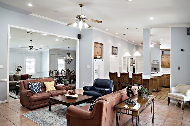 tiled living room with ceiling fan with notable chandelier and ornamental molding