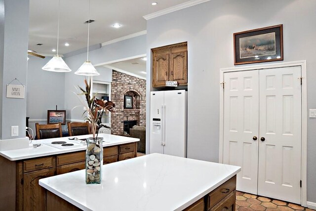 kitchen with pendant lighting, white appliances, brick wall, a fireplace, and crown molding