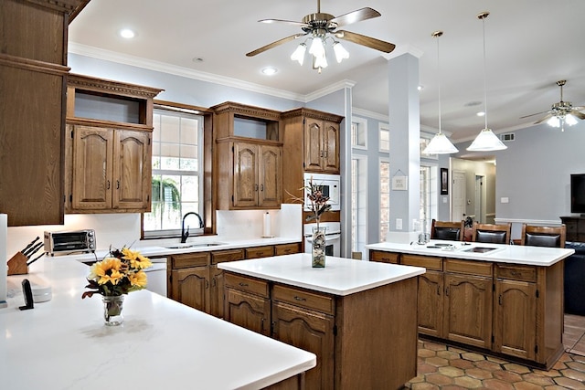 kitchen featuring pendant lighting, a center island, ceiling fan, and sink