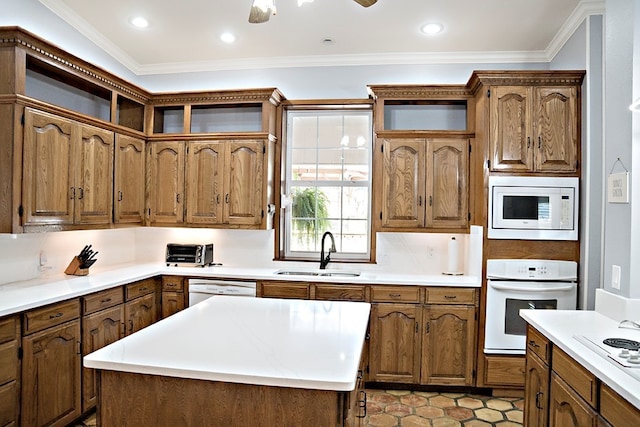 kitchen featuring white appliances, a center island, crown molding, and sink