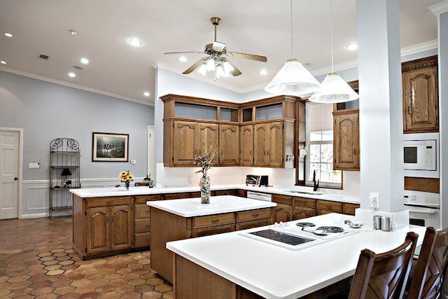 kitchen with ceiling fan, ornamental molding, white appliances, decorative light fixtures, and a center island