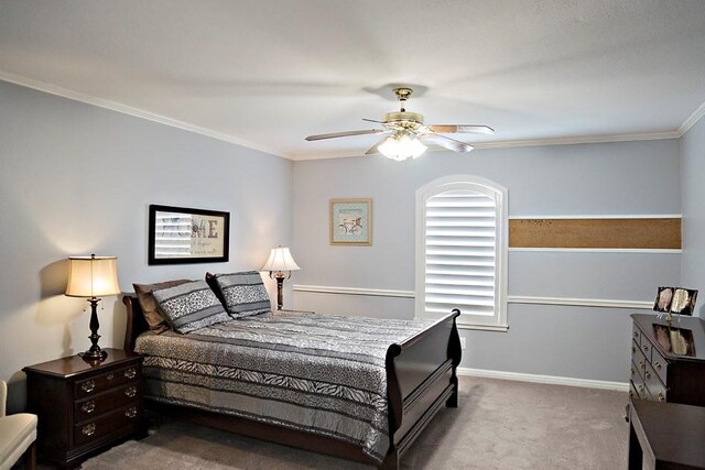 carpeted bedroom with ceiling fan and ornamental molding