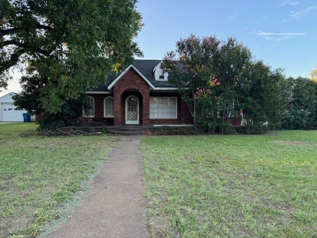 view of front of home with a garage, covered porch, and a front yard